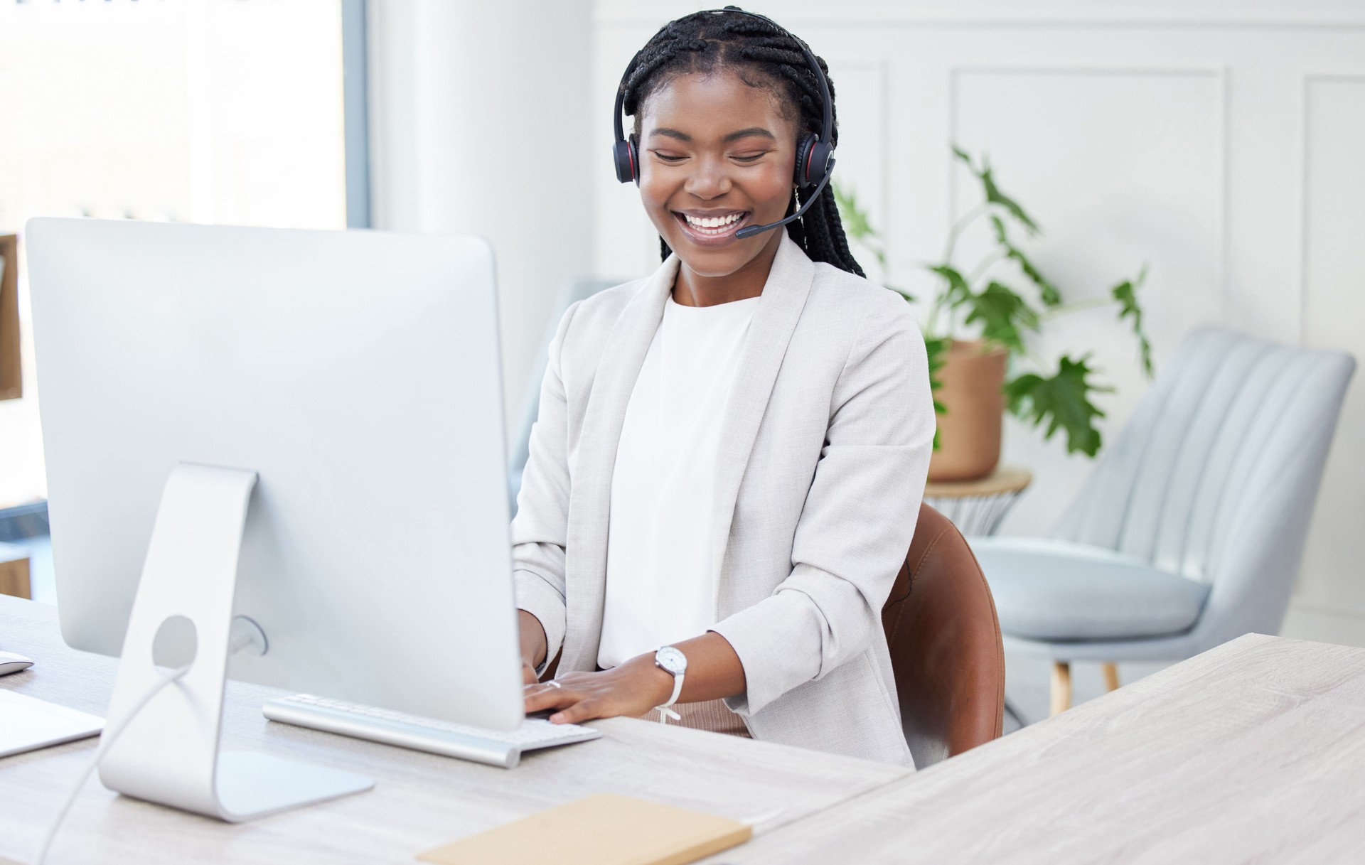 Shot of a young african woman working on her PC in a call center